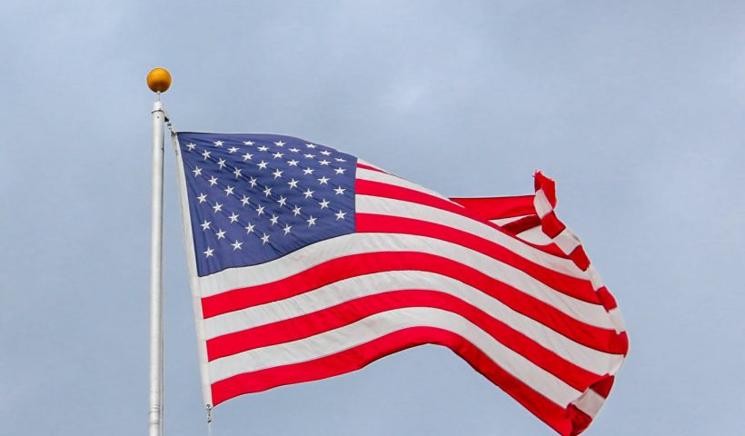 usa flag waving on white metal pole